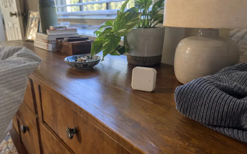 Small white wireless room sensor on a bedroom dresser